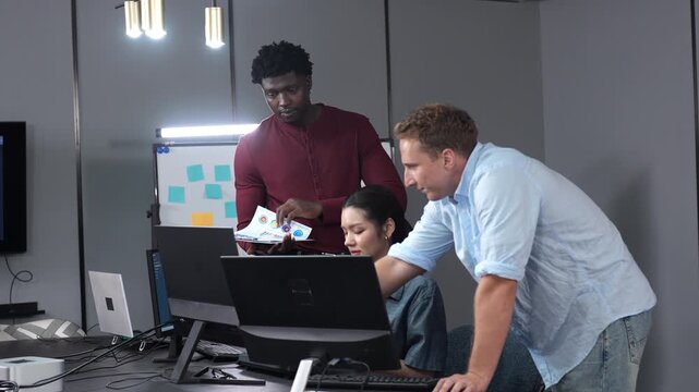 Diverse software developer team collaborating on computer code in modern IT office, Male programmers and female colleague brainstorming future technology business innovations and smart digital system