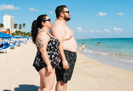 Plus-size couple enjoying a sunny day at the tropical beach vacation