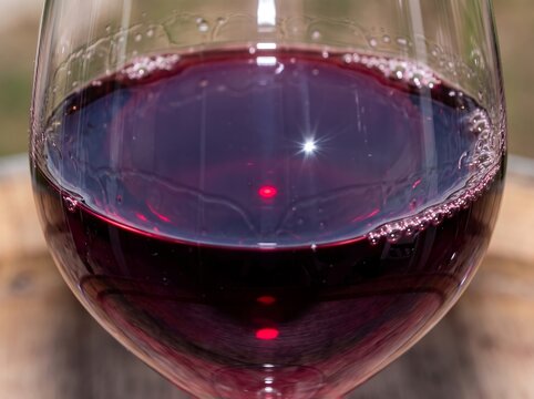 Red Wine Glass Close Up Showcasing Deep Burgundy Liquid and Sparkling Light Reflection