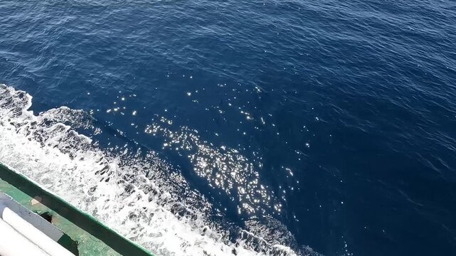 Deep blue sea texture with white waves and nautical ship railing.