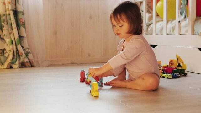 Child playing with a colorful toy train shaped like numbers at home, learning through play.