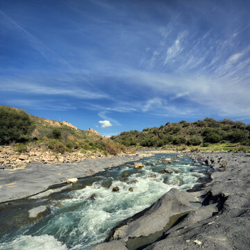 rapids of Simeto River and erosion of volcanic basalt in Sicily, Italy (landscape)