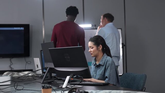 Asian happy woman and man programmer team coding software at computer in dark tech office, Concept of digital transformation, modern cyber security, startup teamwork and future IT digital network