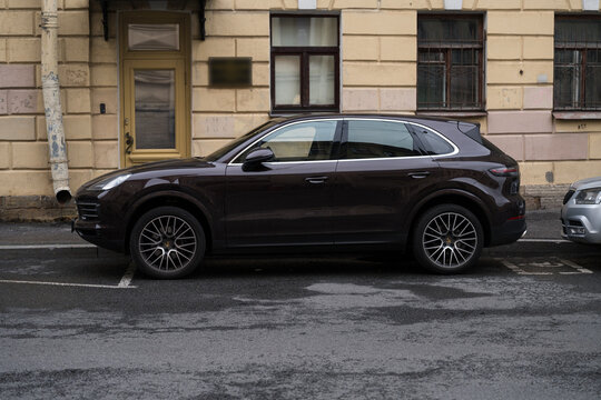 Saint Petersburg, Russia &mdash; July 21, 2026: Dark brown Porsche Cayenne luxury SUV car parked on city street. Side view of premium executive crossover automobile.