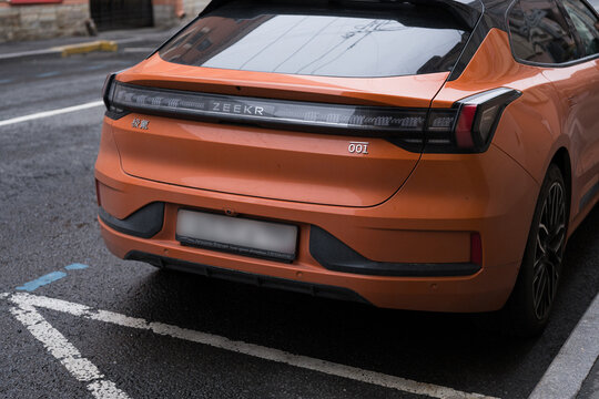 Saint Petersburg, Russia &mdash; July 21, 2026: Orange Zeekr 001 electric car parked on city street. Rear view close up of modern Chinese EV liftback automobile.