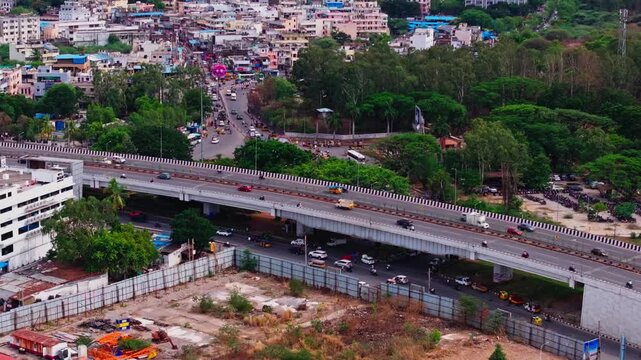 Bird eye view of Bhel Flyover with underpass road, traffic flow, buildings and BHEL township at lingampally, Hyderabad, telangana, india. day time, push in shot, tilt down shot, drone shot, 4k.