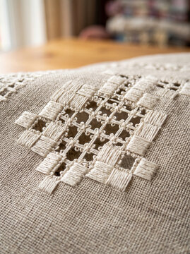 Hardanger needlework openwork geometric pattern on coarse natural linen fabric