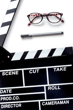 Screenwriter desktop with movie clapper board white background top view