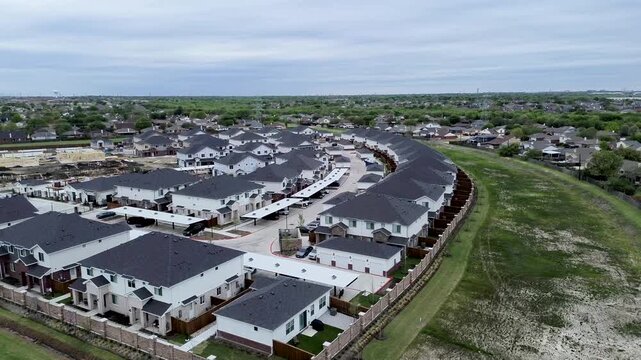 Attached rental cottages sweep along Mansfield Webb Road at Yardly Eden property line. Stone privacy fencing, parking shelters, open grading border newer homes, Arlington, Texas