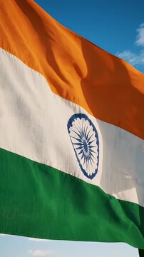 Indian Flag Waving Against Blue Sky - A close-up shot of the Indian flag with its saffron, white, and green stripes gently flapping in the wind.