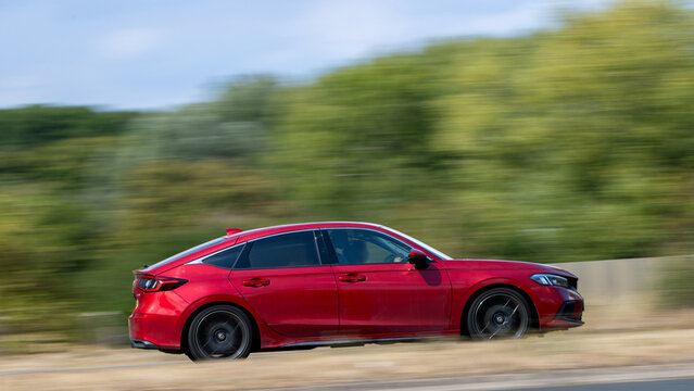 Milton Keynes; UK - Aug 26th 2026: Red Honda Civic Hatchback car in motion driving on a British road