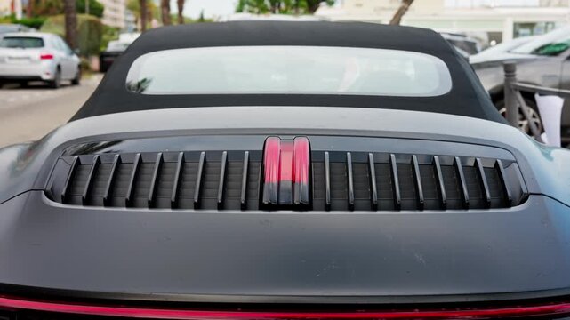 Rear deck lid ventilation grille of modern black luxury convertible sports car.