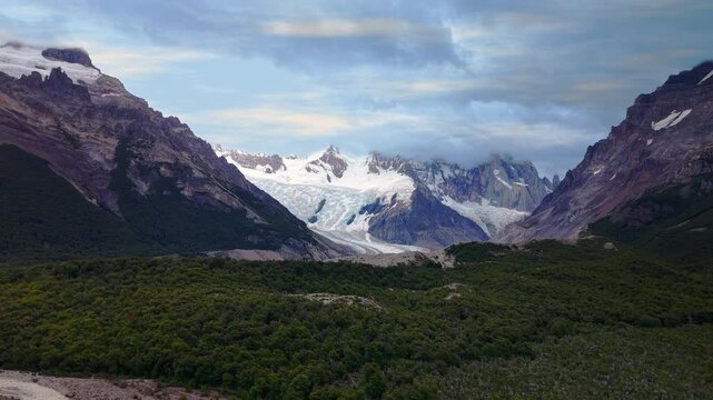 Aerial panoramic view of the majestic Cerro Torre glacier and lake in Los Glaciares National Park, Patagonia, Argentina. Snow-capped Andes mountains and dramatic cloudy sky