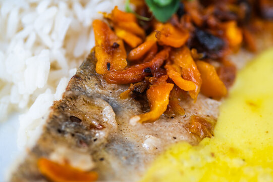Detail of zander fillet, saffron sauce and rice.