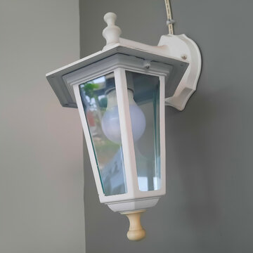 This is a traditional carriage-style outdoor wall sconce (or outdoor lantern wall light), Classic coach/carriage lantern featuring a white frame, clear glass panels, and decorative top and bottom fini