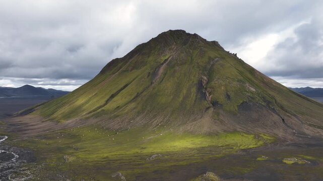 Aerial view of Maelifell mountain in a black sand desert with meandering glacial rivers in the central highland of Iceland, F232