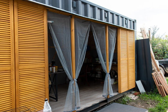 Modern modular wooden container house with open patio and curtains
