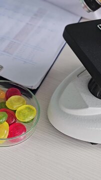 Examining colorful candies under a microscope in a lab setting