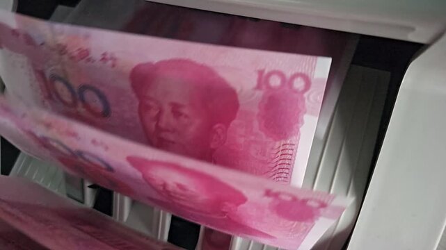 Counting money at a bank in China during the morning hours with a cash counting machine