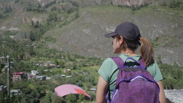 A woman gazes from a viewpoint at the beautiful town of Cotahuasi located in the valley of the same name in Peru.