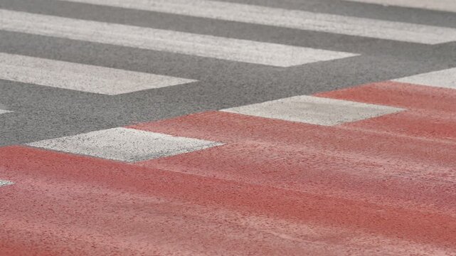 People cycling along red bike lane in modern urban street, clear pavement markings separating cyclists from traffic, sustainable transportation, active mobility and city infrastructure