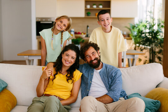Happy family portrait with parents and children relaxing at home