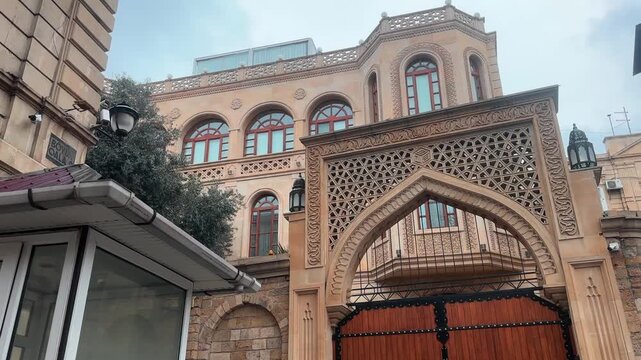 Arched gate in urban stone setting with trees and neutral mood, static front-facing view of wooden and metal structures, brown and beige tones, commercial real estate and architecture use.