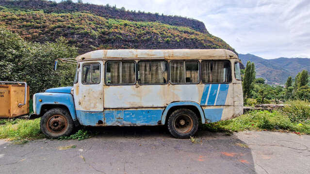 Old, rusty KAVZ-685 bus (GAZ front end) by the roadside against a mountain backdrop in Alaverdi; vintage Soviet bus, abandoned site, Lori Province, Caucasus region, Armenia 20.08.2025