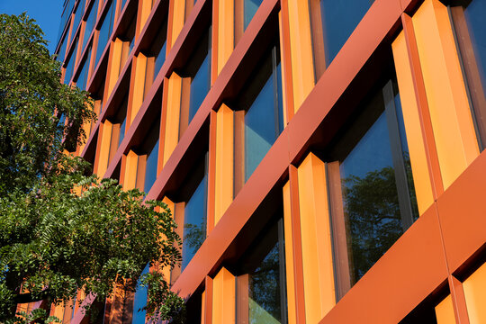 Modern Orange Building Facade With Glass Windows And Trees Urban Architecture Background