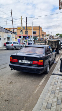 Black BMW 5 Series E34 sedan from the 1980s and 1990s parked by the roadside in Gyumri; a classic German "youngtimer" car; Shirak, Caucasus, Armenia 29.8.25