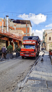 A red Isuzu NPR truck driving through a narrow alley in the old town of Gaziantep&mdash;a Japanese commercial vehicle from the 1990s&mdash;in Southeastern Anatolia, T&uuml;rkiye 13.09.2025