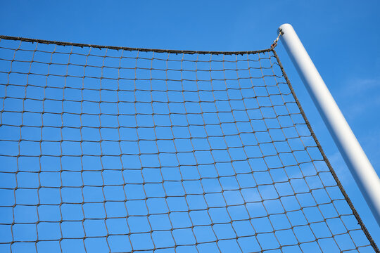Net supported by a metal post used in outdoor sports courts.