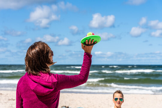 Woman And Child Playing Catch Ball Game On Beach During Summer Family Vacation By Sea