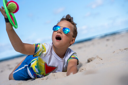 Happy Child Playing Paddle Ball On Beach During Summer Vacation Outdoor Fun And Recreation