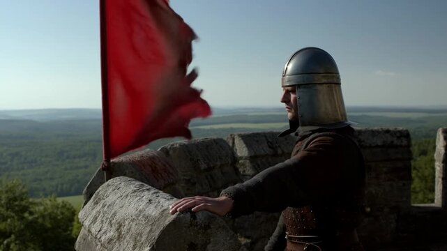 Medieval knight in helmet overlooks countryside from stone castle battlement