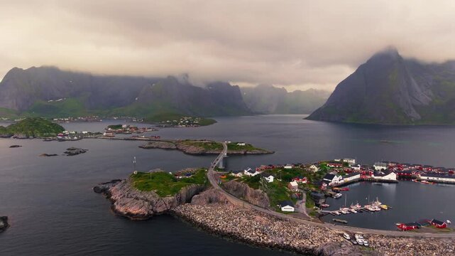 Aerial view of Hamn&oslash;y fishing village surrounded by rocky islands, fjord waters and dramatic mountains in the Lofoten archipelago, Northern Norway