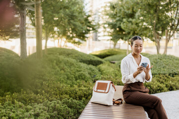 Fototapeta premium Korean woman enjoying a peaceful moment in a lush urban park setting