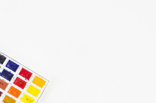 top view Colorful  watercolor palette isolated on white background. copy space. splattered pigments and blending spots, ideal for artistic backgrounds and design resource templates.