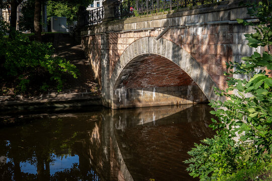 Historic Stone Arch Bridge Reflected in a Calm Urban Canal