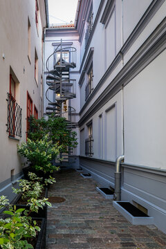Metal Spiral Staircase in a Narrow Historic Courtyard