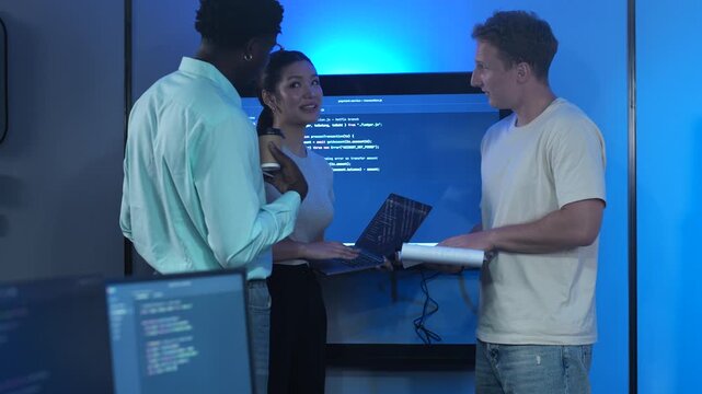 Diverse tech startup IT teams meeting in modern office. Asian female and male software developers analyzing coding innovation on laptop. Corporate technology teamwork and business development concept