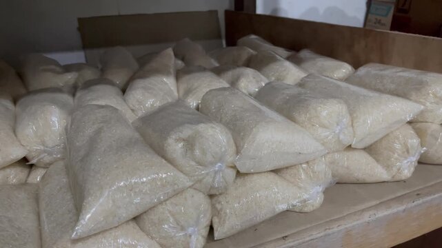 Symmetrical rows of granulated white sugar packed in clear plastic bags
