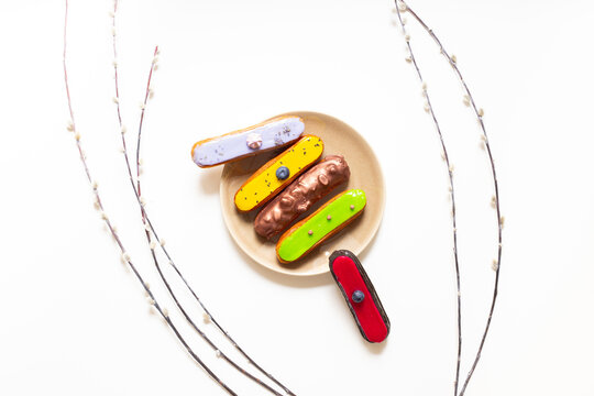 French eclairs served on plate - colorful artisan dessert composition with soft daylight, top view food photography
