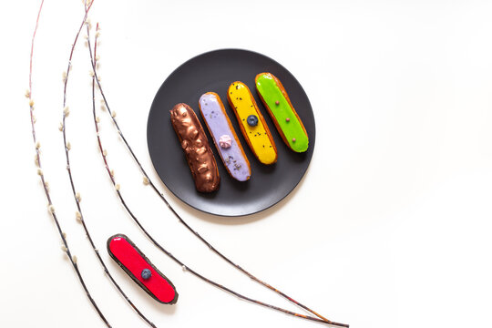 French eclairs served on plate - colorful artisan dessert composition with soft daylight, top view food photography