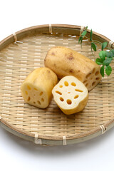 竹ざるに盛った新鮮なれんこんと断面 © Wakko