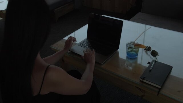 Woman managing laptop, notes and daily tasks during demanding work session, concept of mental workload and productivity pressure