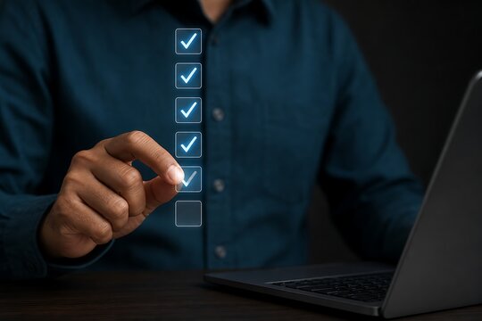 Hand selecting a checkbox on a digital checklist near a laptop