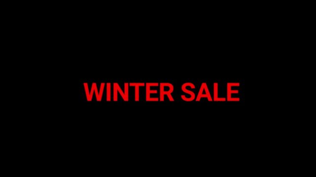 Winter sale text written in glowing red neon lettering stands out against a pitch-black background to advertise seasonal price cuts.