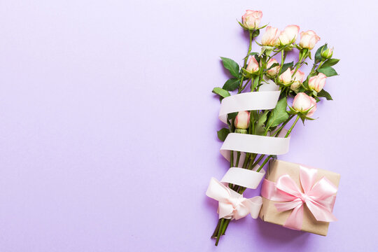 design concept with pink rose flower and gift box on colored table background top view. Happy Holiday, Mothers day, birthday concept. Romantic flat lay composition