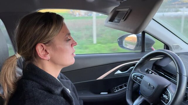 Woman driving car on road trip, side profile shot. Static interior camera angle captures her thoughtful expression during a peaceful afternoon journey.